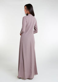 This Box Pleat Abaya Taupe features a fluid, A-line cut with a neat box pleat that runs from the high neck line to the bottom of the garment. The abaya is lightweight and airy, and a slip is necessary to wear underneath. 