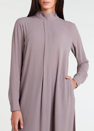 This Box Pleat Abaya Taupe features a fluid, A-line cut with a neat box pleat that runs from the high neck line to the bottom of the garment. The abaya is lightweight and airy, and a slip is necessary to wear underneath. 