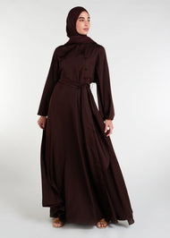 This mid-weight abaya boasts a subtle shine and features a flared silhouette, an oriental-style neckline, self fabric buttons and includes an optional belt. Dark brown colour. 
