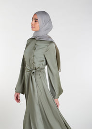 Crafted from a light weight silk-like fabric with a subtle sheen, this abaya features a fitted oriental style bodice and self fabric buttons, flaring from the waist. Olive Green colour.