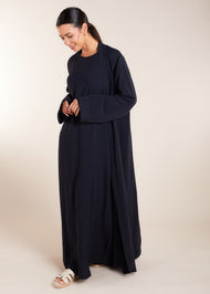 This elegant Two Piece Open Abaya set includes a Full Sleeve matching inner dress. Perfect for everyday wear, it can also be dressed up with accessories for an evening look. The open abaya can be worn as a maxi on its own or paired with the inner dress for a stylish ensemble. In navy.