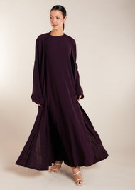 This elegant Two Piece Open Abaya set includes a Full Sleeve matching inner dress. Perfect for everyday wear, it can also be dressed up with accessories for an evening look. The open abaya can be worn as a maxi on its own or paired with the inner dress for a stylish ensemble. In a deep plum purple shade.